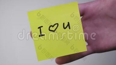 贴纸上的铭文我爱你。 画画`我爱你`心在黄纸上。 铭文我爱你